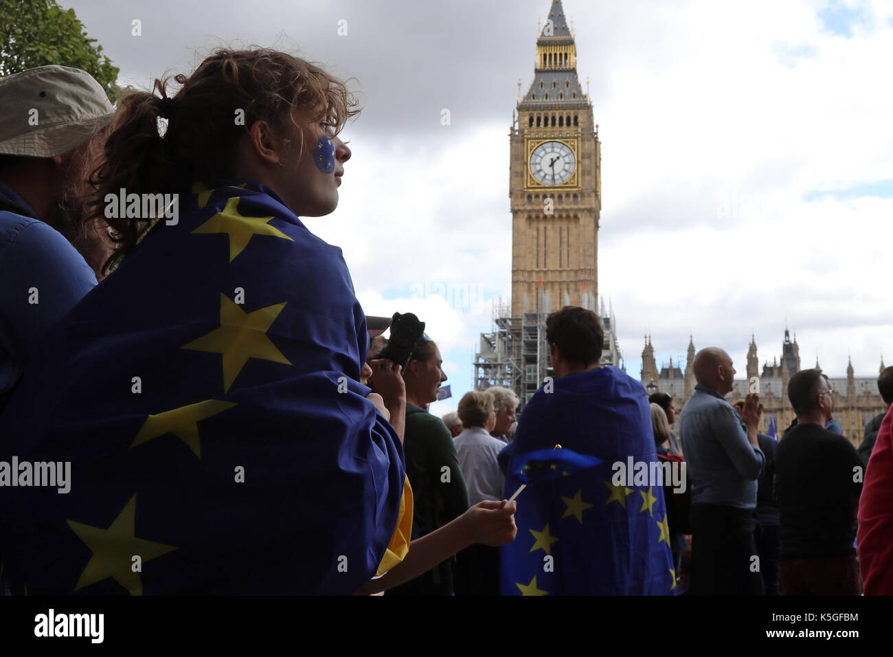 London, UK. 9th Sept, 2017. A girl wrapped in an EU flag stands in Parliament Square Garden in Westminster, central London, during the People's March for Europe, an anti-Brexit rally, on 9 September 2017. The clock tower of Big Ben is in the background. Credit: Dominic Dudley/Alamy Live News Stock Photo