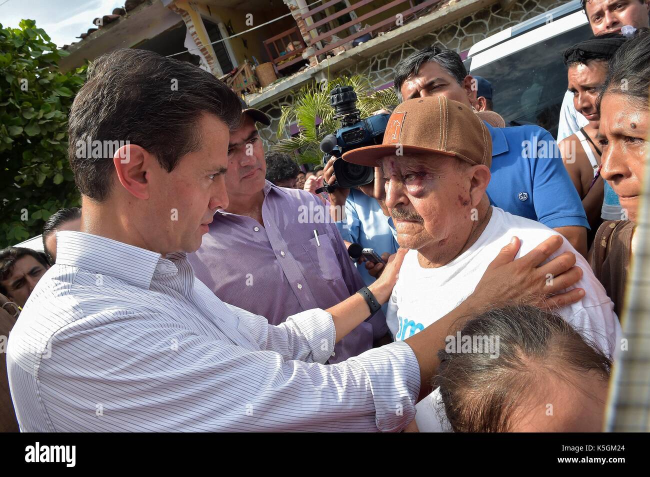 Oaxaca, Mexico. 09th Sep, 2017. Mexican President Enrique Pena Nieto comforts an earthquake survivor during a visit to the coastal town closest to the epicenter September 9, 2017 in Juchitán, Oaxaca, Mexico. The massive 8.2-magnitude quake struck off the southern Pacific coast of Chiapas killing at least 60 people and leveling areas in some southern states. (presidenciamx via Planetpix) Credit: Planetpix/Alamy Live News Stock Photo