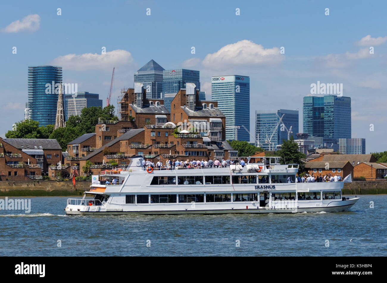 Cruise boat on the River Thames with Canary Wharf financial district in ...