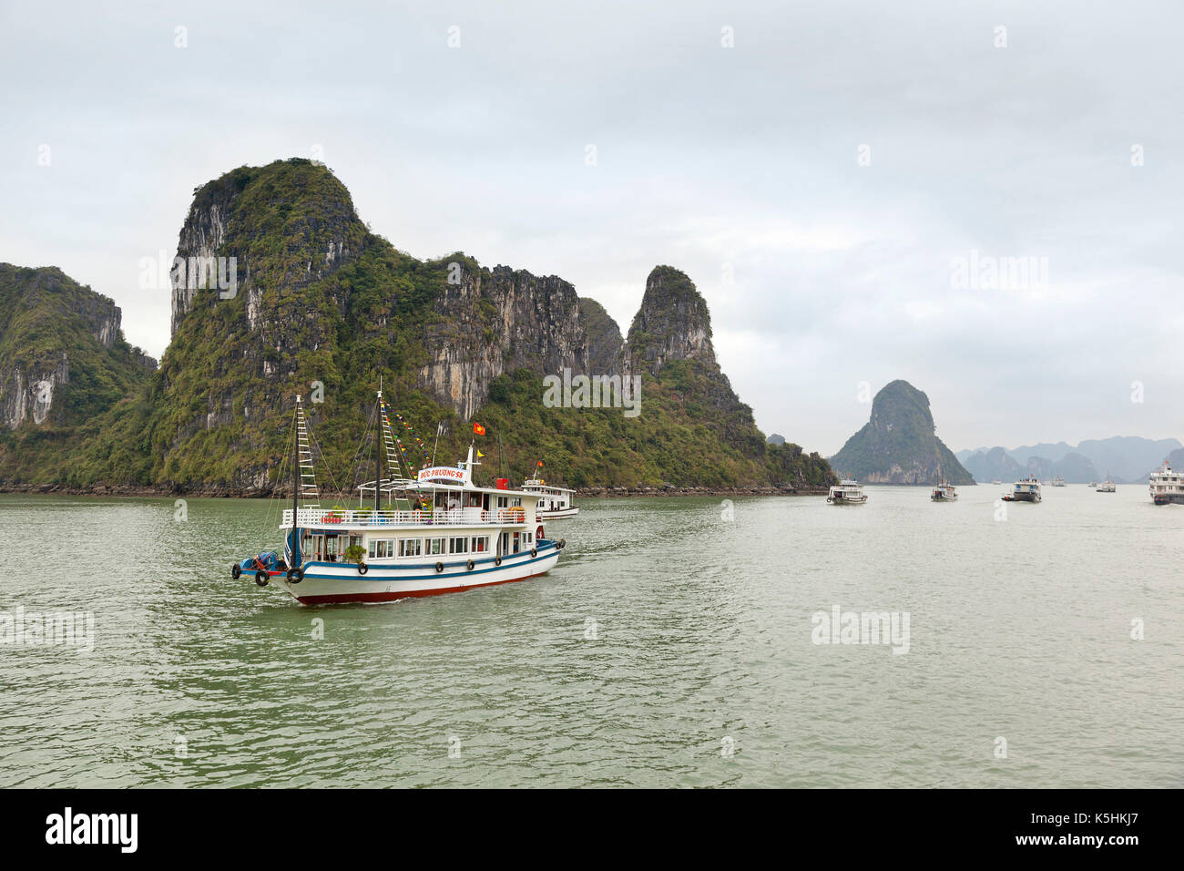Tour boats cruising among the limestone islets, Halong Bay, Vietnam. Stock Photo