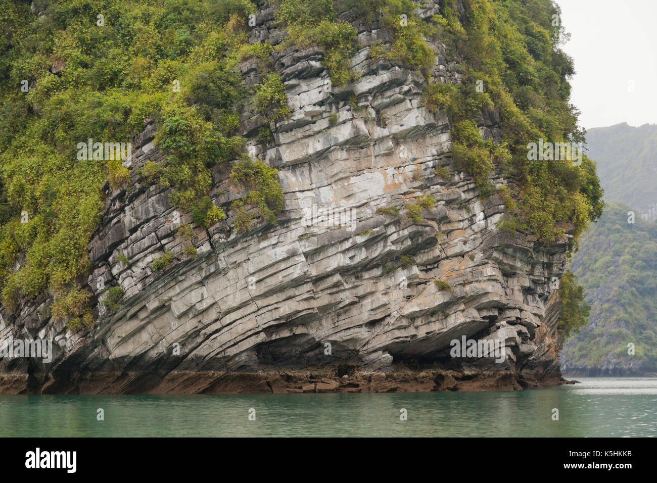Karst outcrop showing sedimentary layers, built up over thousands of years. Halong Bay, Vietnam. Stock Photo