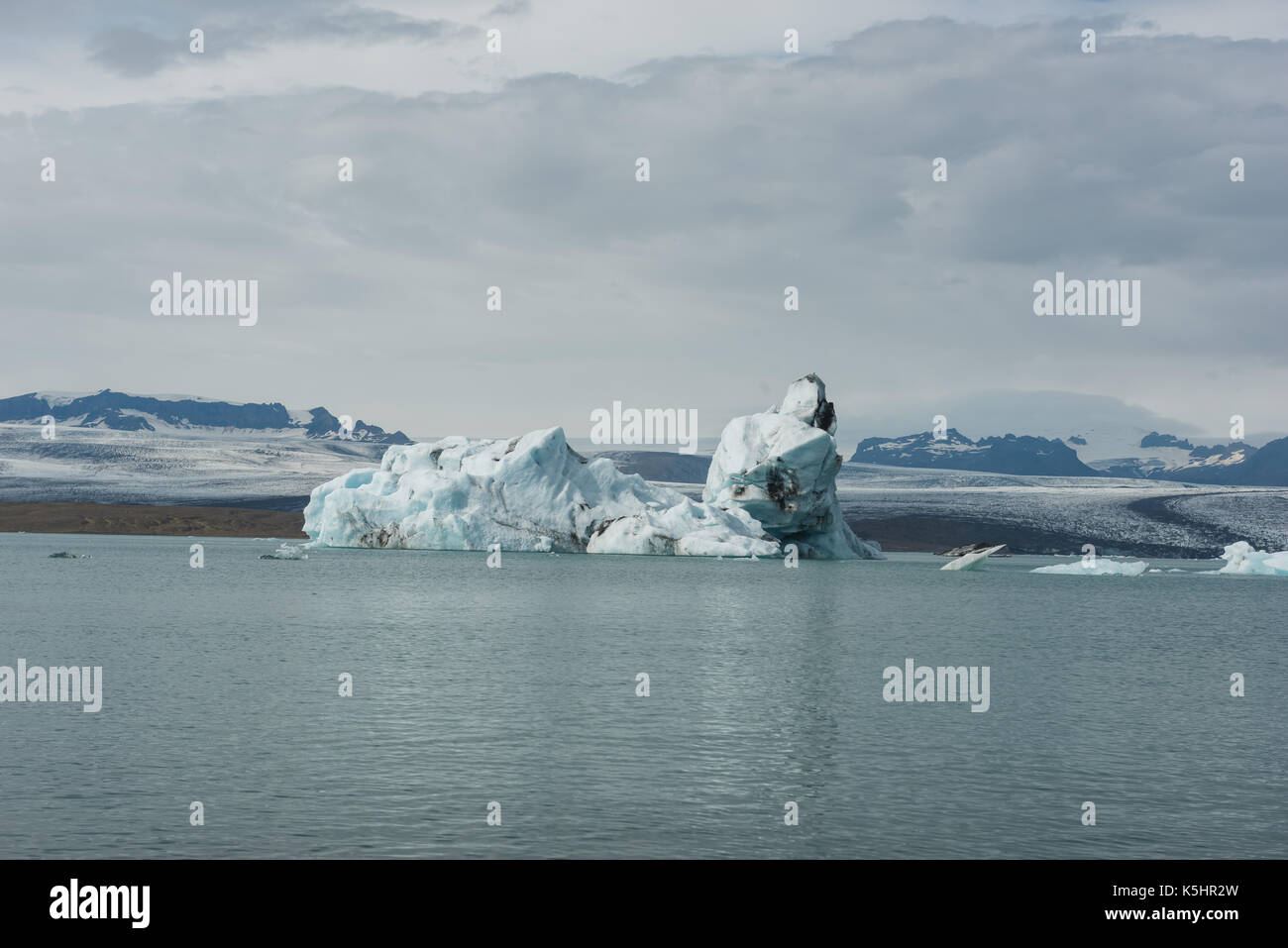 Icebergs floating in a glacial lagoon in front of melting glacier Stock Photo