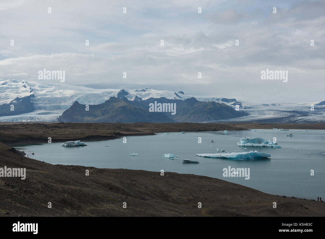 Icebergs floating in a glacial lagoon in front of melting glacier Stock Photo
