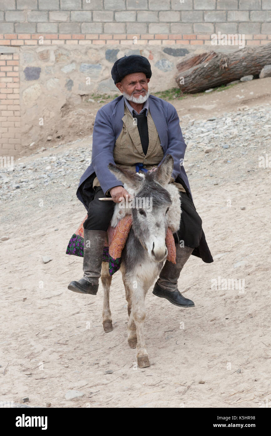 old man riding a donkey in a mountain village Stock Photo