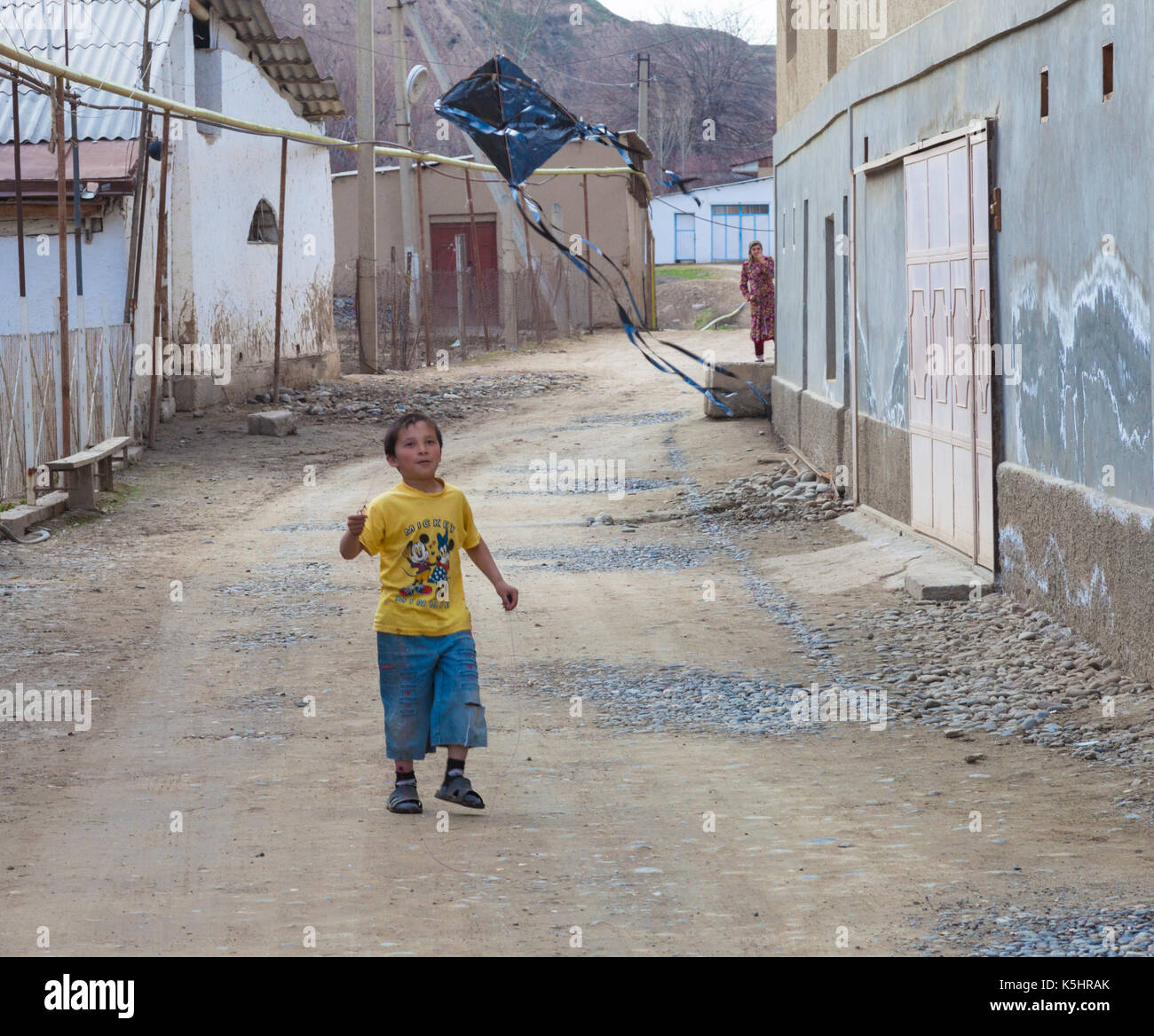 The uzbek boy at the street playing kite Stock Photo