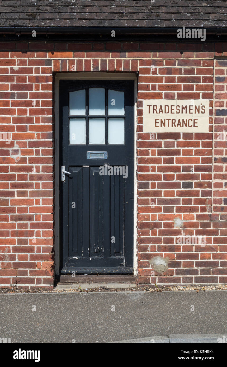Back door to an old pub building displaying a sign saying Tradesmen's Entrance; Heacham, Norfolk, UK Stock Photo