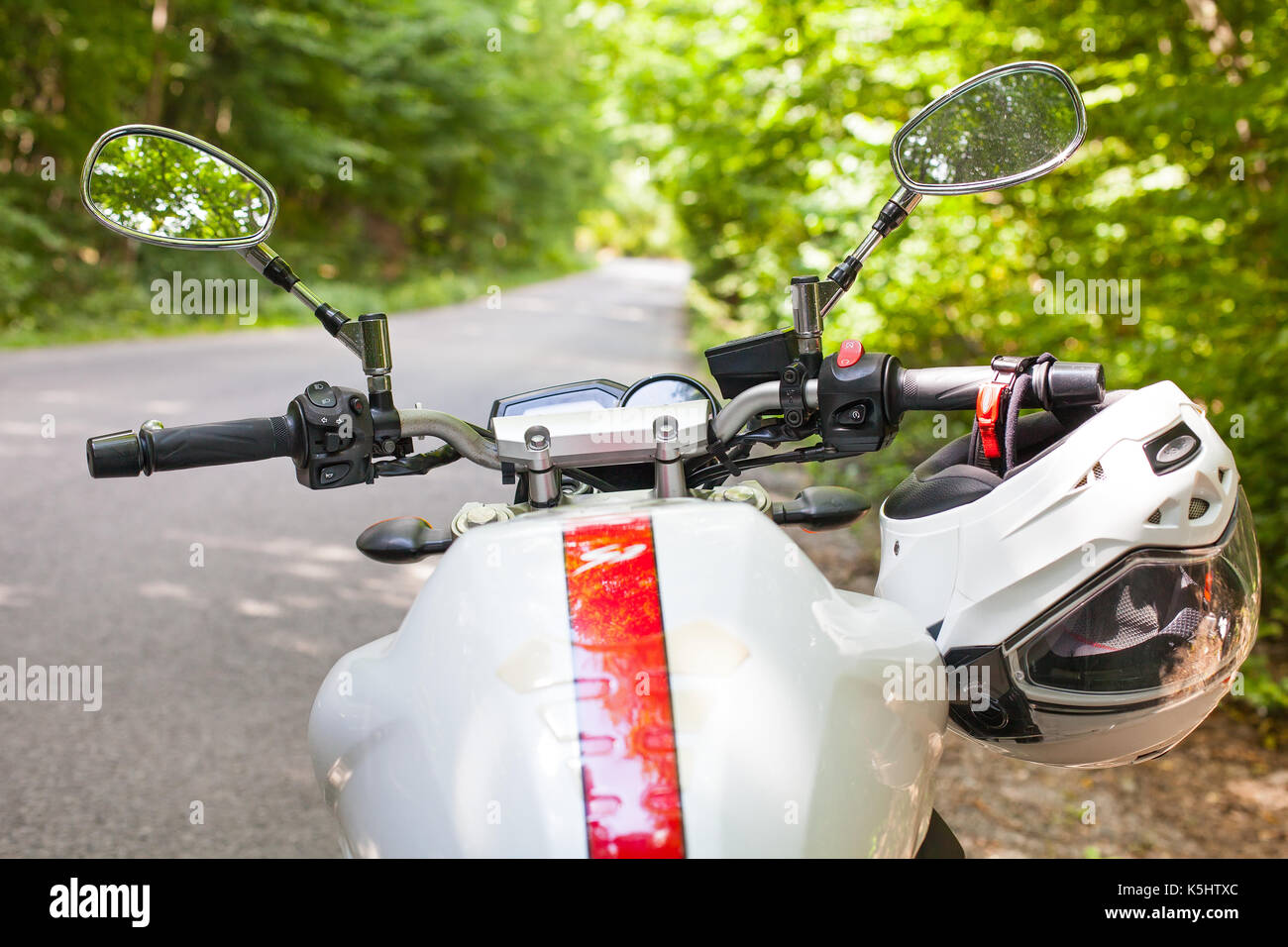 Picture of a motorcycle parked on a country road in a forest Stock ...