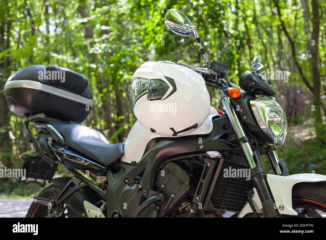 Picture of a motorcycle parked on a country road in a forest Stock ...