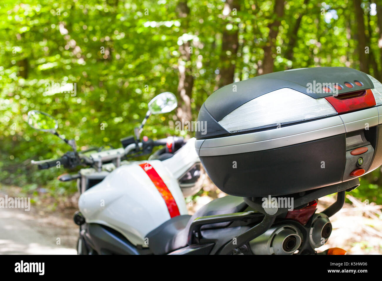 Picture of a motorcycle parked on a country road in a forest Stock ...