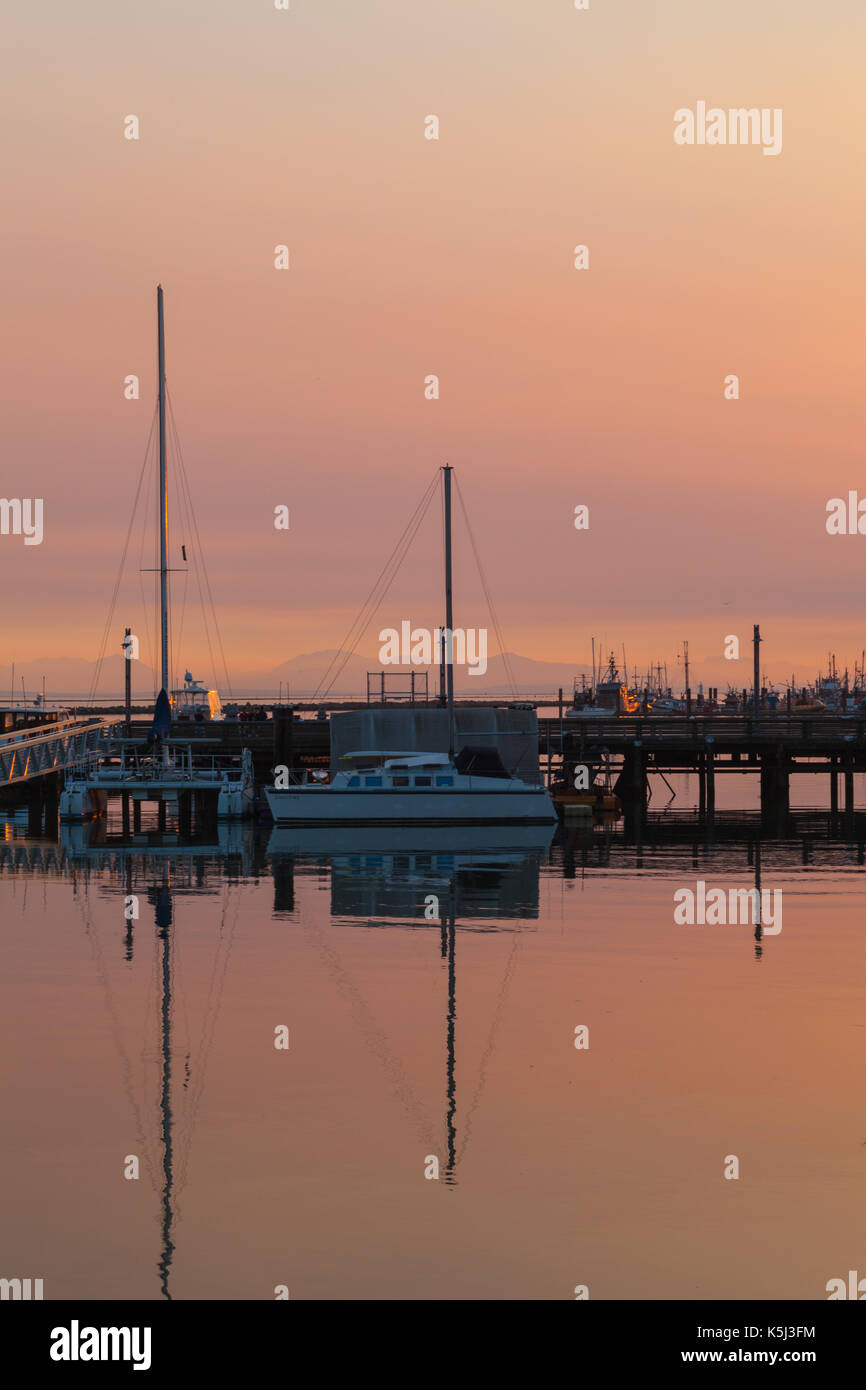 Forest fire smoke adding colour to the setting sun ovet Steveston in British Columbia Stock Photo