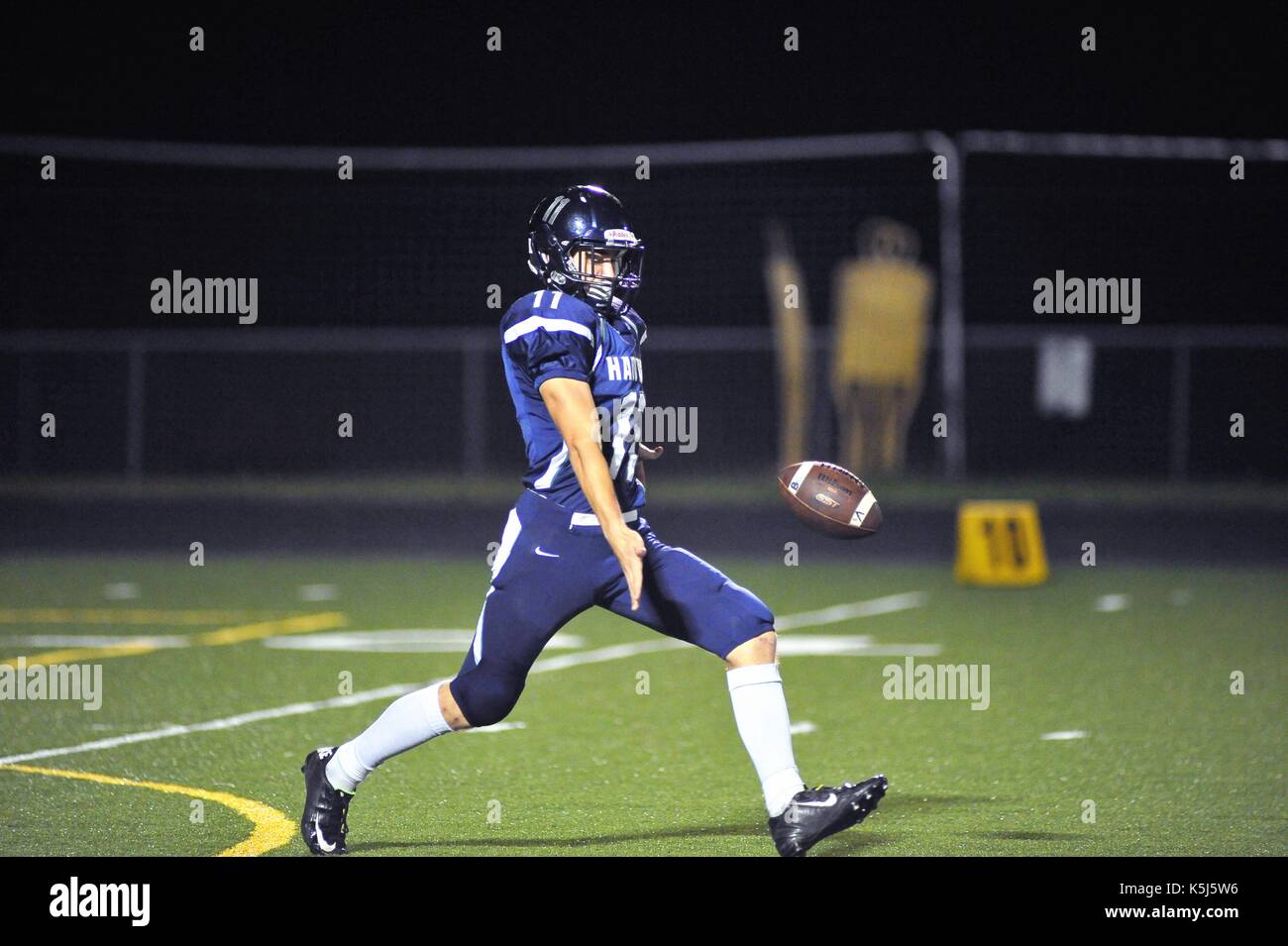 Punter getting off a kick under little pressure during a high school football game. USA. Stock Photo