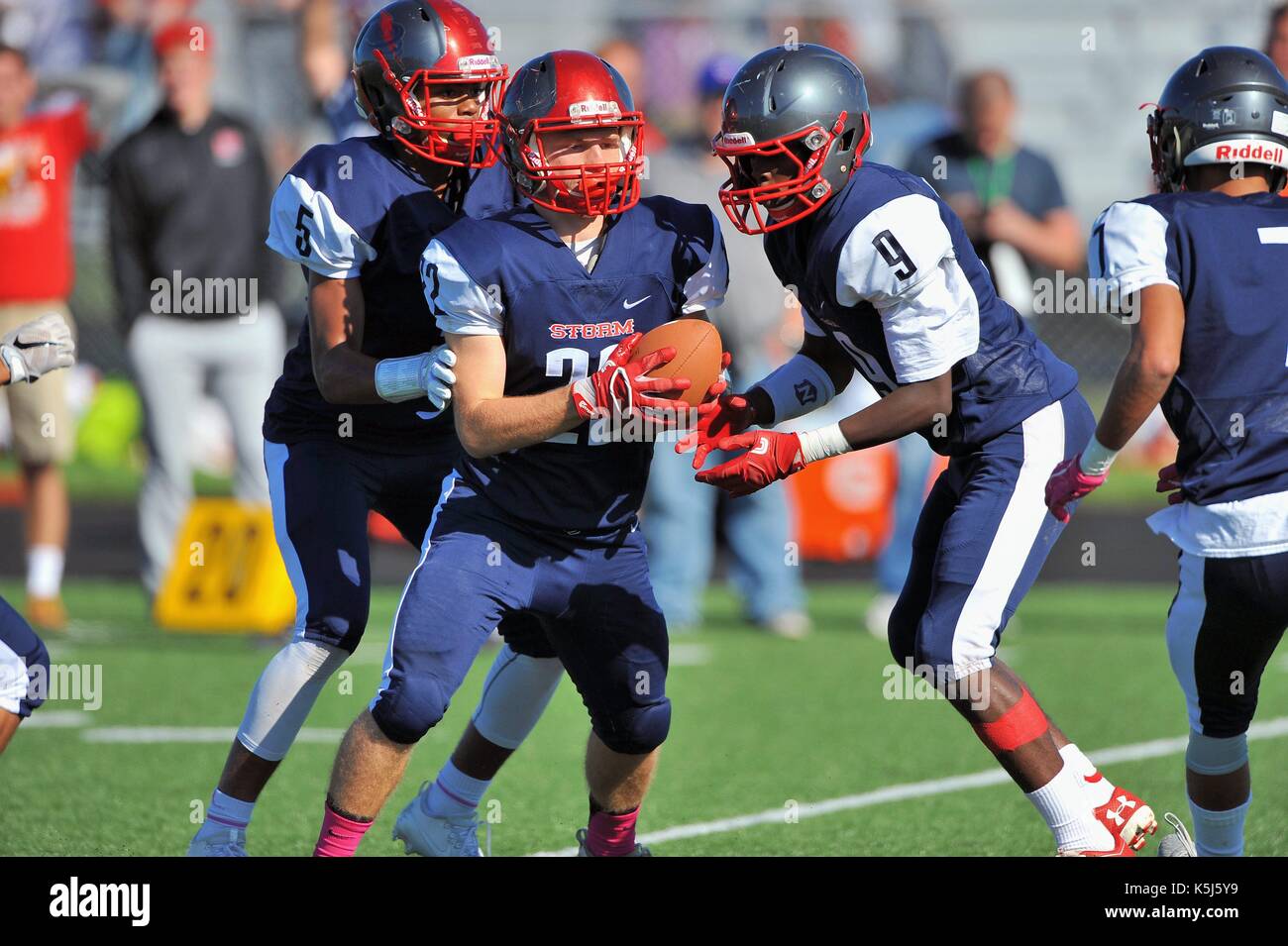 High school running back accepting a hand off from his quarterback. USA. Stock Photo