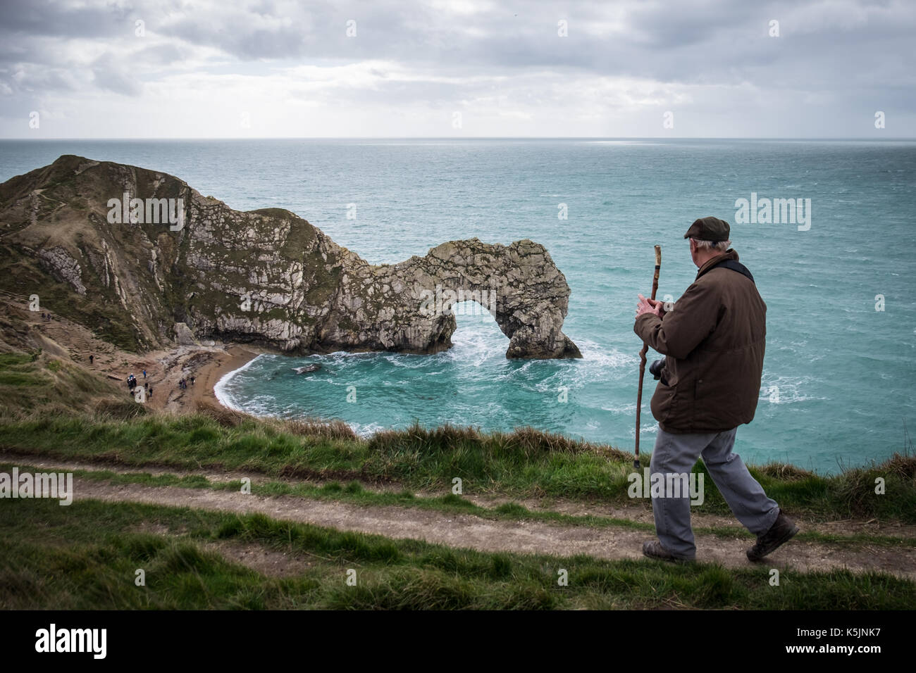A man walking along the coast path at Durdle Door, Dorset, UK Stock Photo