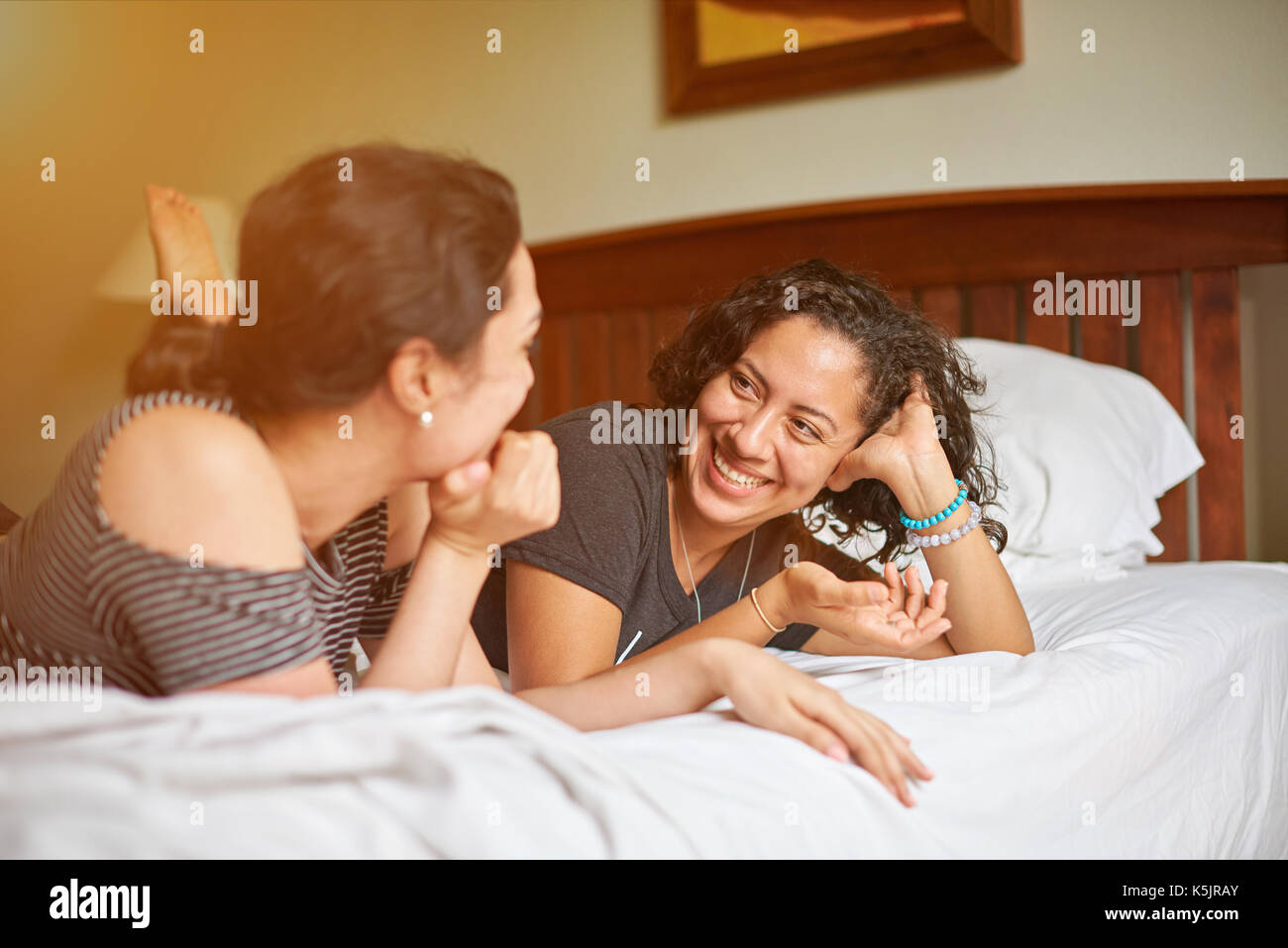 Two younf woman talk laying on bed Stock Photo