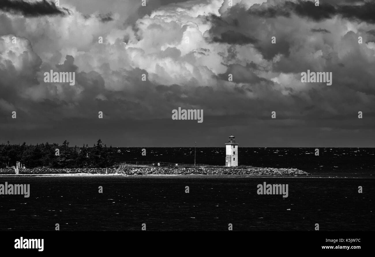 A lighthouse sits on the north western shoreline of Nova Scotia, Canada as seen from a passenger ferry crossing the Northumberland Straight. Stock Photo