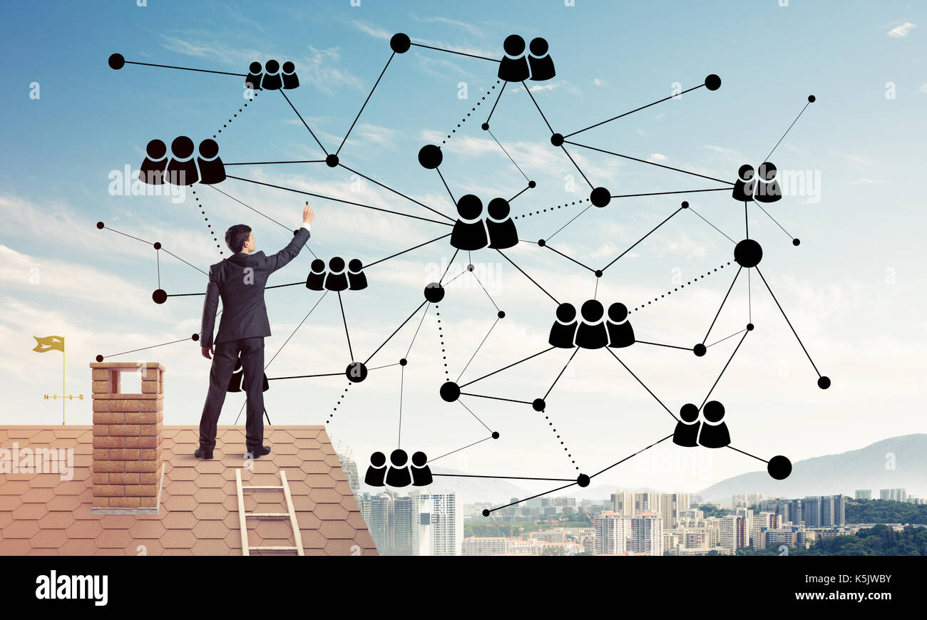 Businessman on house roof presenting networking and connection c Stock ...