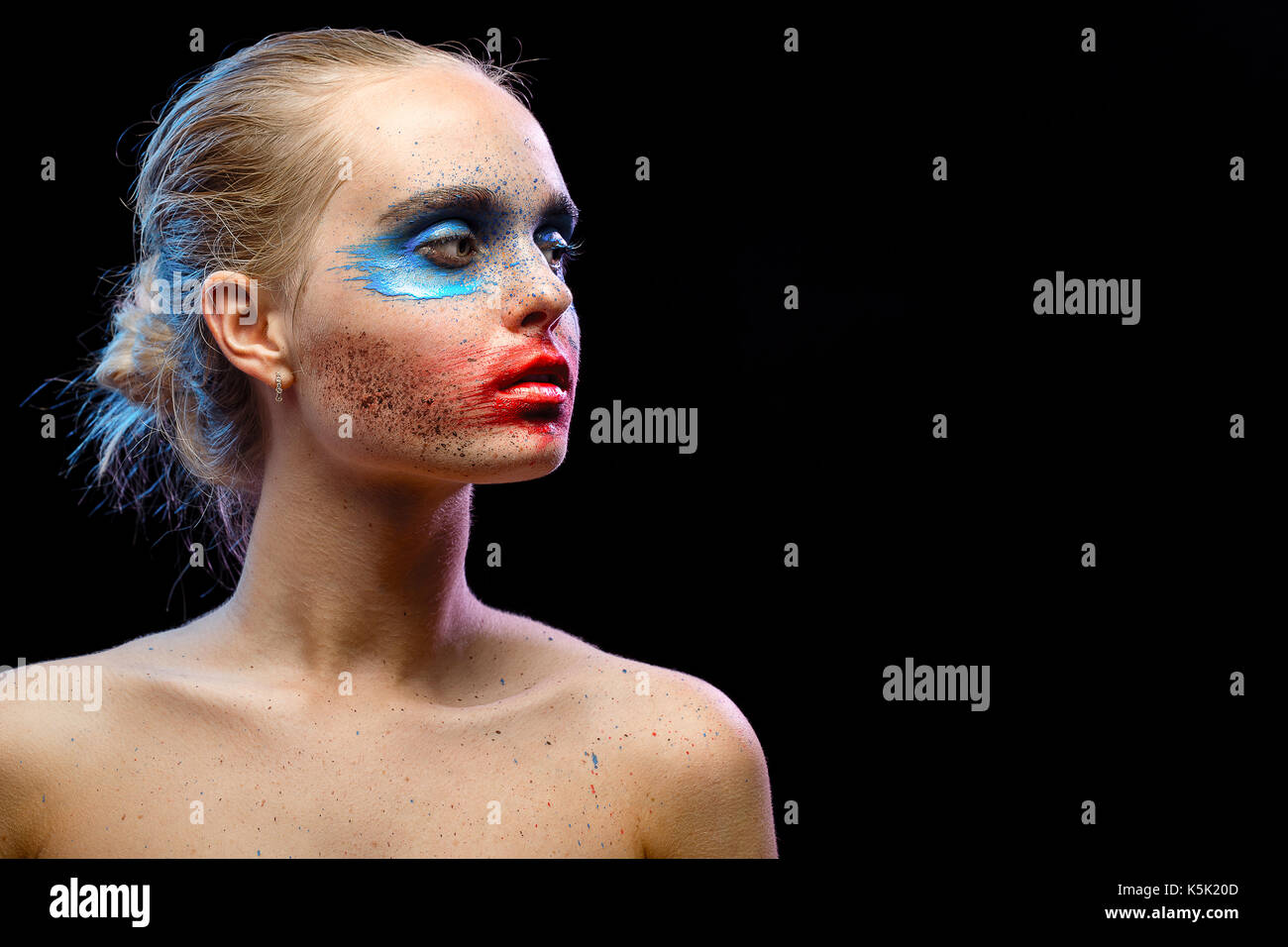 female portrait with creative multicolored makeup on black background Stock Photo