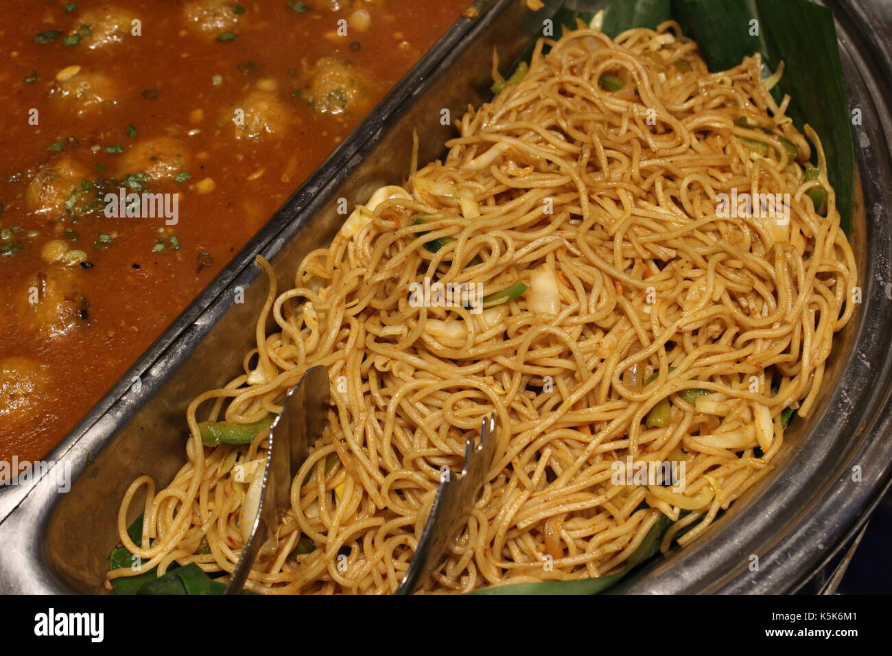 Veg ball in hot garlic sauce and veg noodles served as a part of the main course of a buffet at a restaurant Stock Photo