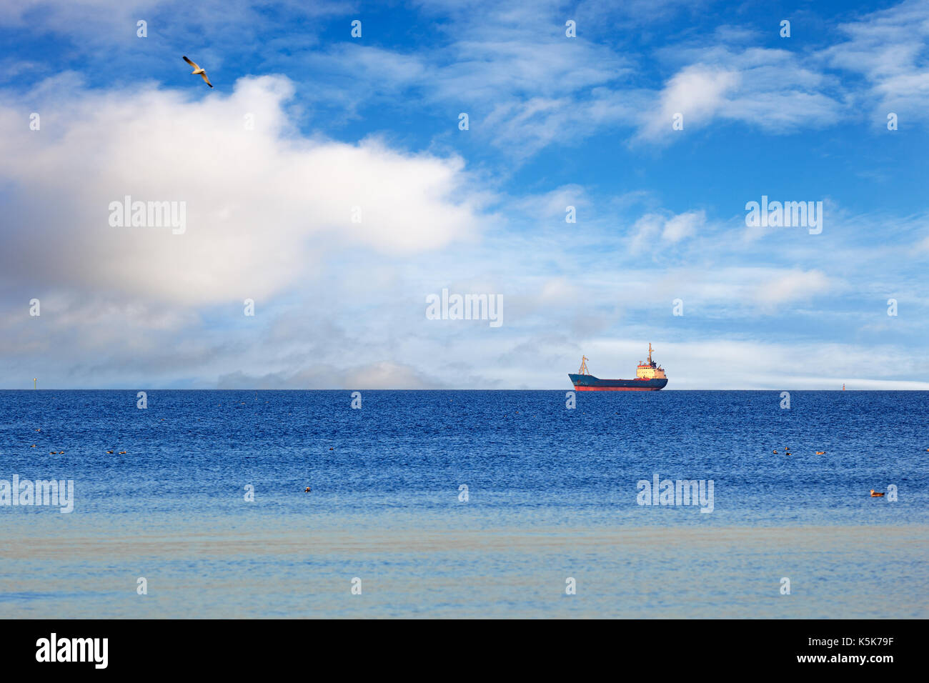 A cargo ship floating on a calm sea. Stock Photo