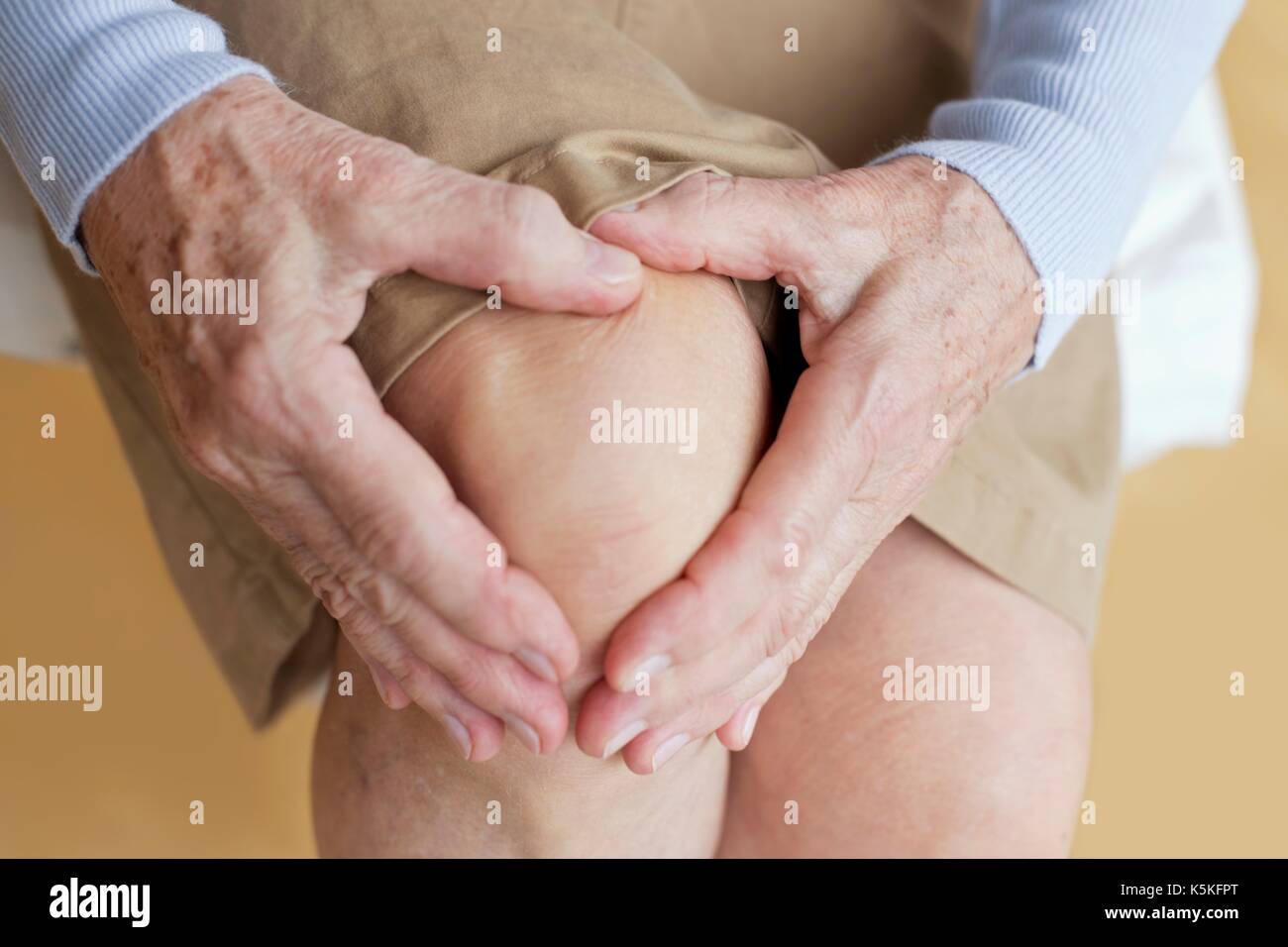 Senior woman holding sore knee. Stock Photo