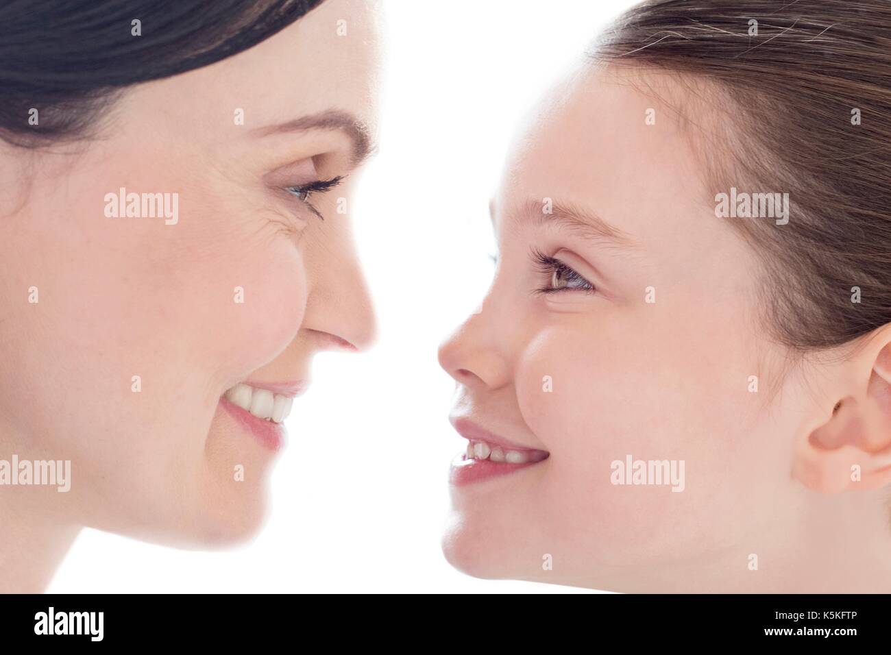 Mother and daughter face to face, smiling. Stock Photo