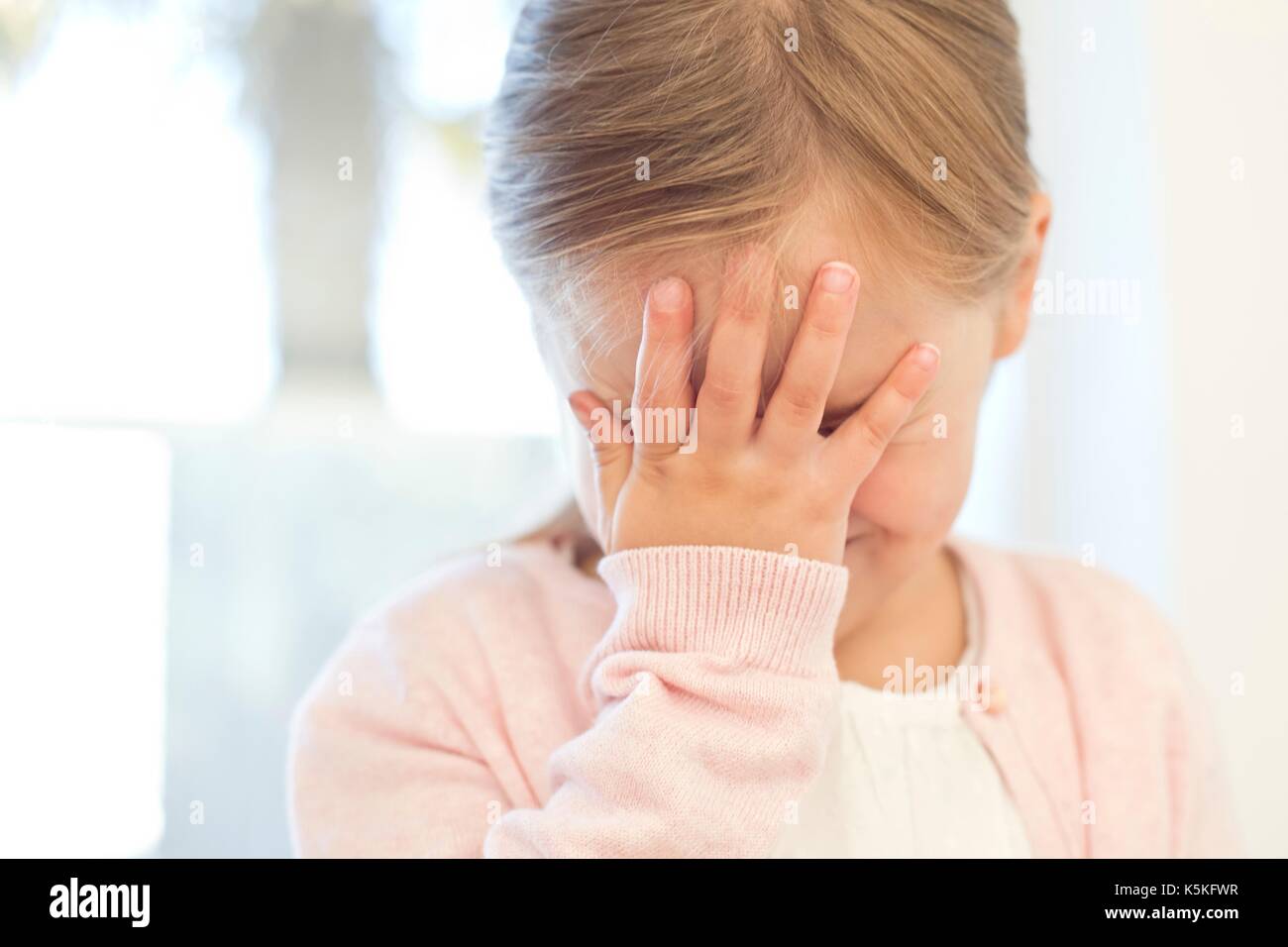 Young girl with hand on face. Stock Photo
