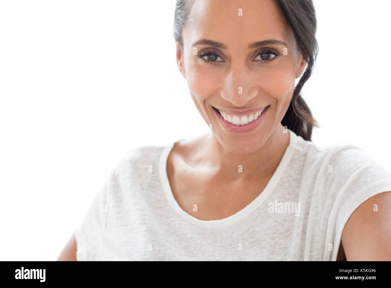 Mid adult woman smiling towards camera, portrait. Stock Photo