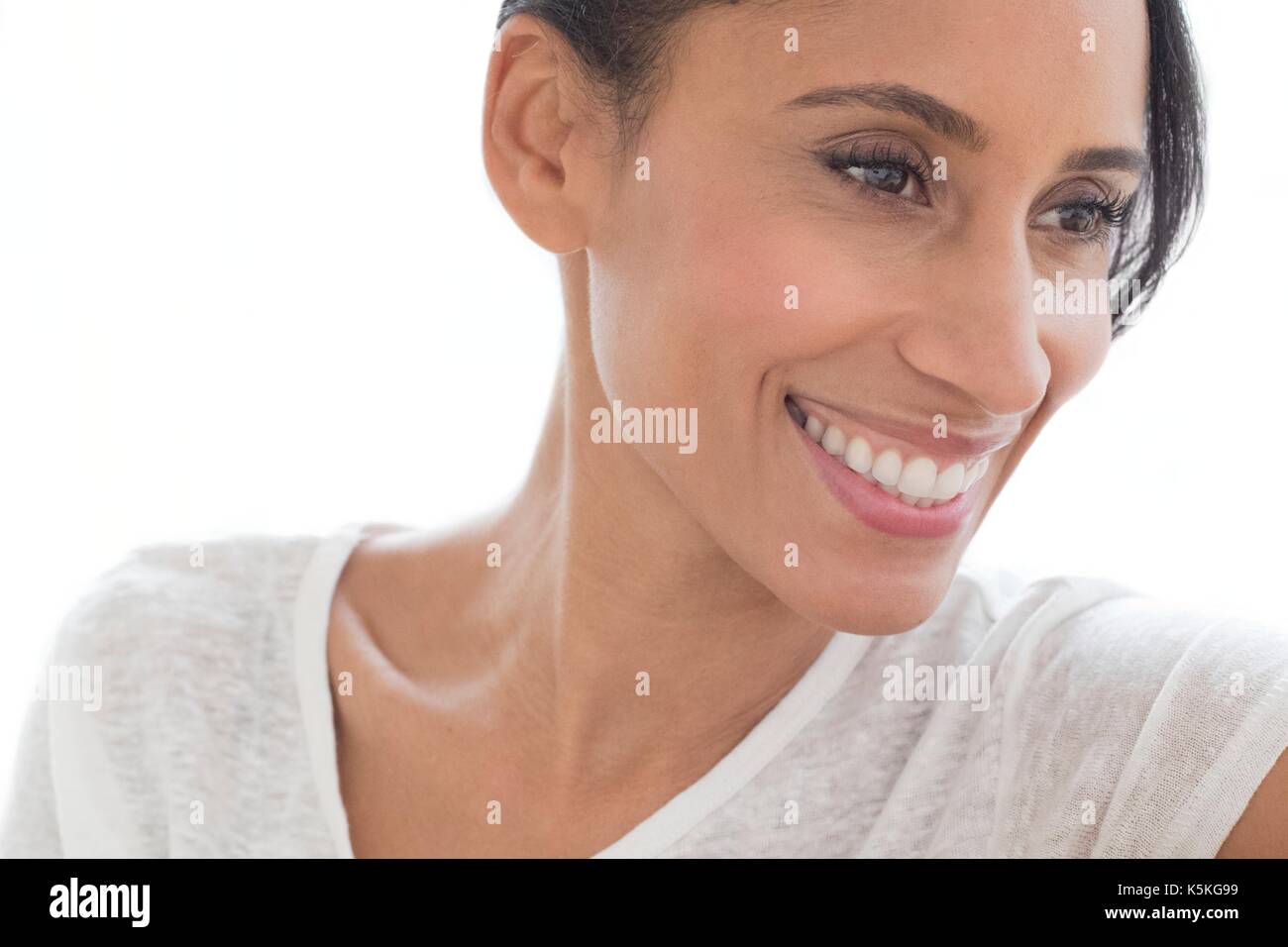 Mid adult woman smiling and looking away, portrait. Stock Photo