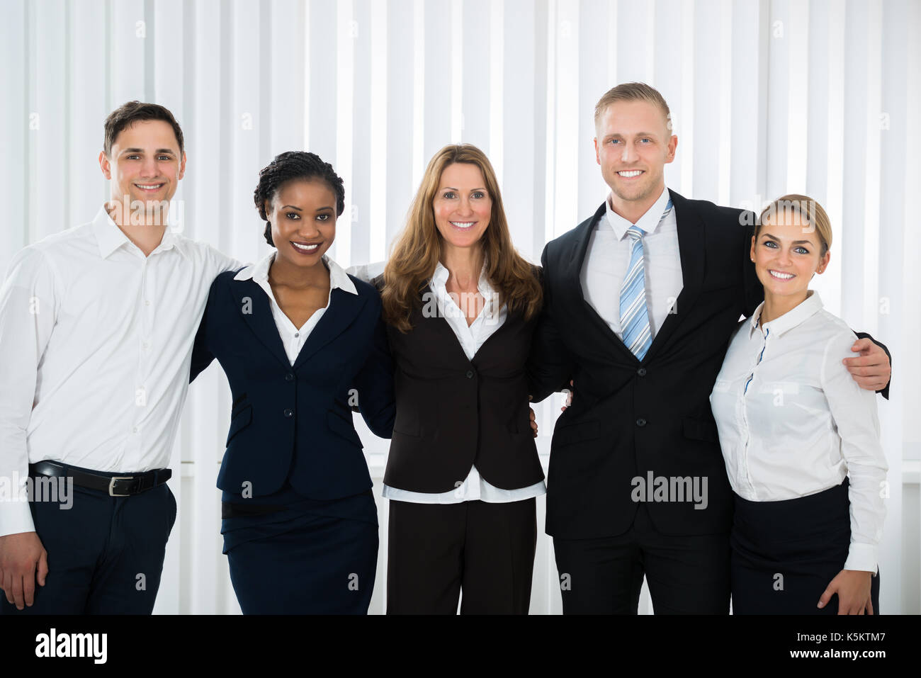 Group Of Happy Businesspeople Standing In Office Stock Photo - Alamy