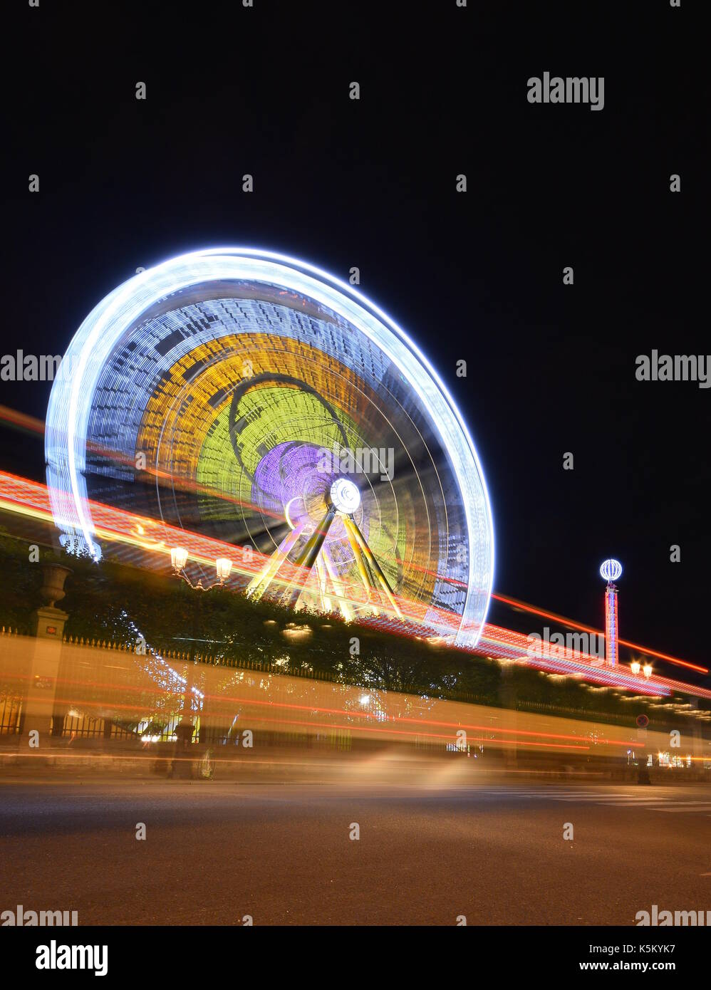 Ferris Wheel long exposure with car light trails Stock Photo