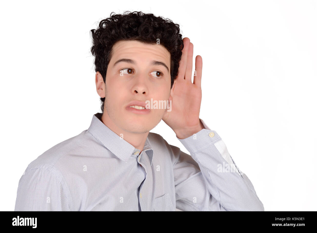 Portrait of attractive young man hearing something. Isolated white background. Stock Photo