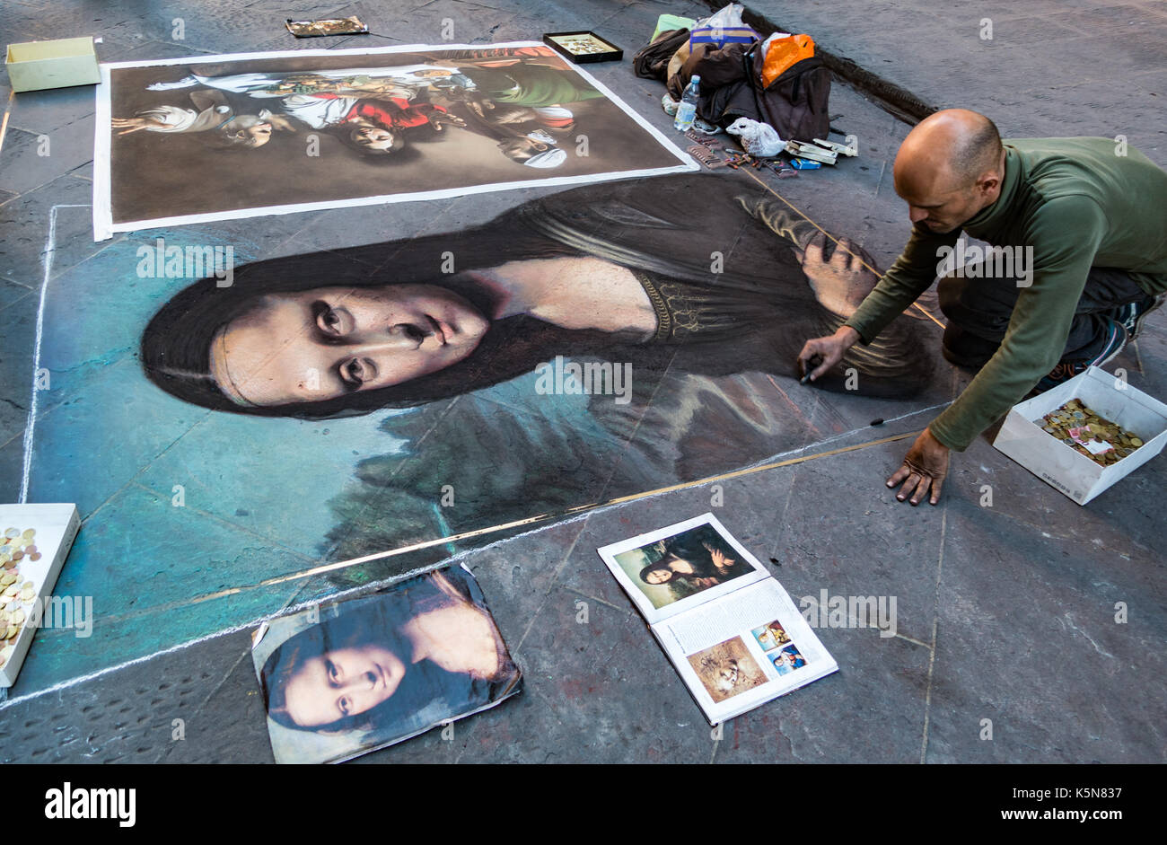 Florence, Italy - Apr 23, 2017: Man paints the Mona Lisa in chalk on the street Stock Photo