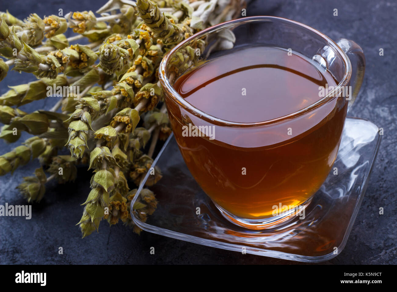 Mountain tea. Sideritis herbal tea and flowers on black slate stone selective focus Stock Photo