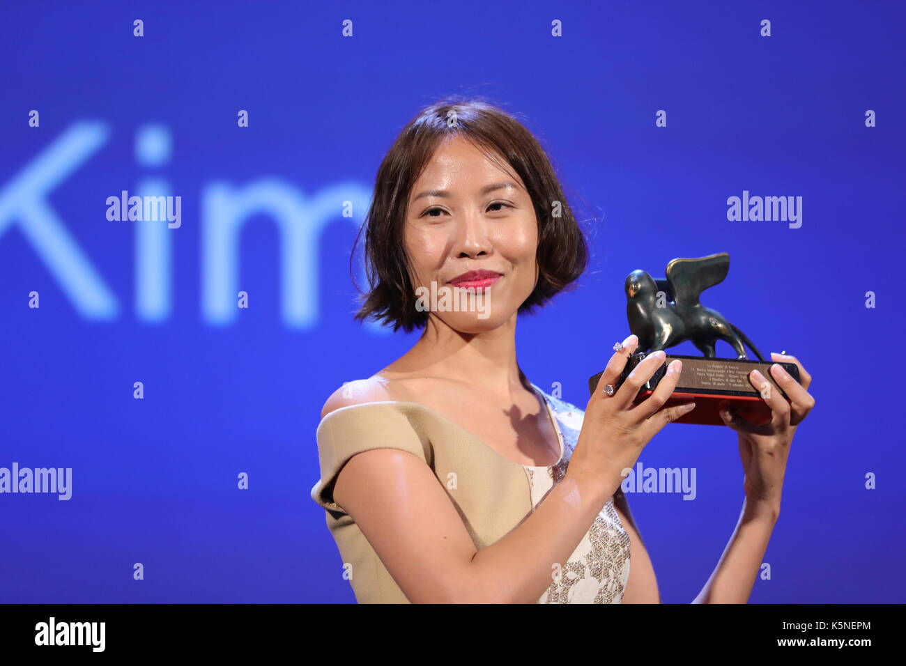 VENICE, ITALY - SEPTEMBER 09: Gina Kim receives from John Landis the Best VR (Virtual Reality) award for the movie 'Bloodless' during the award ceremony of the 74th Venice Film Festival on September 9, 2017 at Venice Lido. Stock Photo