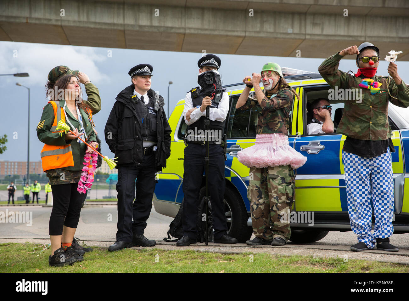 London, UK. 9th September, 2017. The Clandestine Insurgent Rebel Clown Army performs close to a police surveillance camera during a protest by activists from many different campaign and faith groups outside the ExCel Centre against the arms trade and the arms fair to be held at the venue next week. DSEI is the world's largest arms fair and military delegations invited by the British government include states named by the Foreign Office as a 'human rights priority', namely Bahrain, Colombia, Egypt, Pakistan and Saudi Arabia. Credit: Mark Kerrison/Alamy Live News Stock Photo