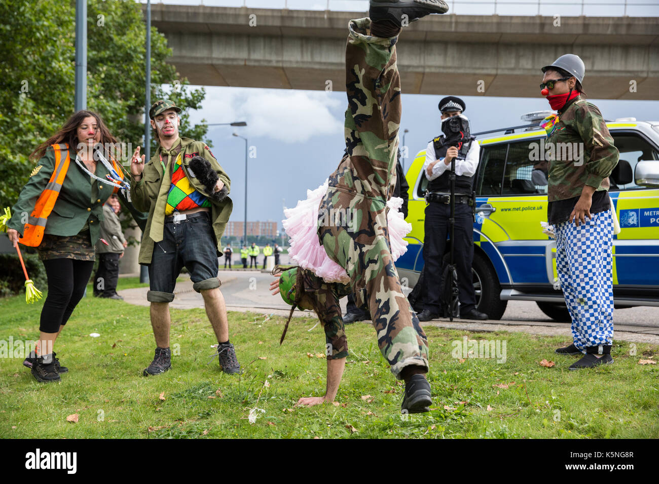 London, UK. 9th September, 2017. The Clandestine Insurgent Rebel Clown Army performs close to a police surveillance camera during a protest by activists from many different campaign and faith groups outside the ExCel Centre against the arms trade and the arms fair to be held at the venue next week. DSEI is the world's largest arms fair and military delegations invited by the British government include states named by the Foreign Office as a 'human rights priority', namely Bahrain, Colombia, Egypt, Pakistan and Saudi Arabia. Credit: Mark Kerrison/Alamy Live News Stock Photo