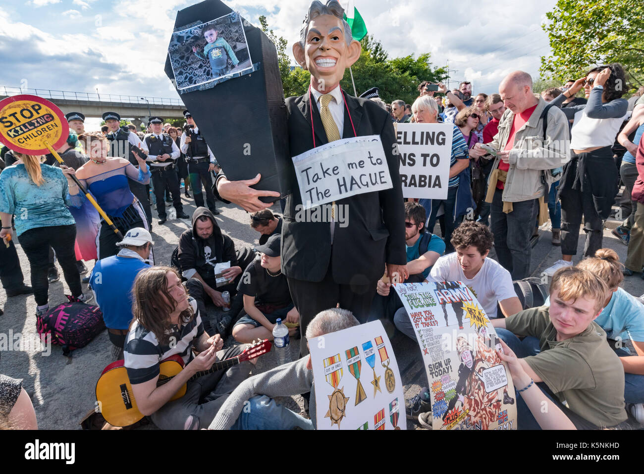 London, UK. 9th Sep, 2017. London, UK. 9th September 2017. Protesters, including a man in a TOny Blair mas with a placard 'Take me to the HAGUE' and a small coffin block the road at the Festival of Resistance at the East gate of the worlds's largest arms fair, DSEI, the Defence & Security Equipment International. The arms fair is backed by the UK government and is where arms companies and arms dealers sell weapons to countries around the world including many repressive regimes. Police tried to clear the road and made several arrests. Peter Marshall Images Live (Credit Image: © Peter Mar Stock Photo