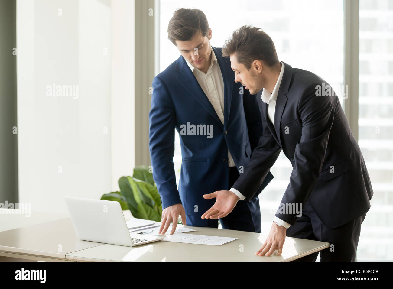 Architects discussing construction plan drawings Stock Photo