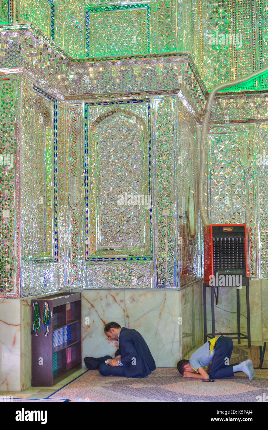 Fars Province, Shiraz, Iran - 18 april, 2017:  Mirrored mausoleum in Sayyed Alaeddin Hossein Mosque, Muslims pray and read the Koran. Stock Photo
