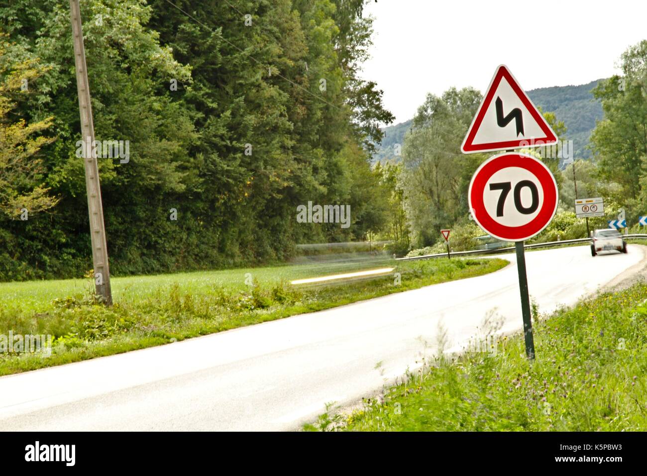 Speed limitation for cars, trucks, motor vehicles, car traffic, with a sign indicating a maximum speed of 70 kilometers on a national in France Stock Photo