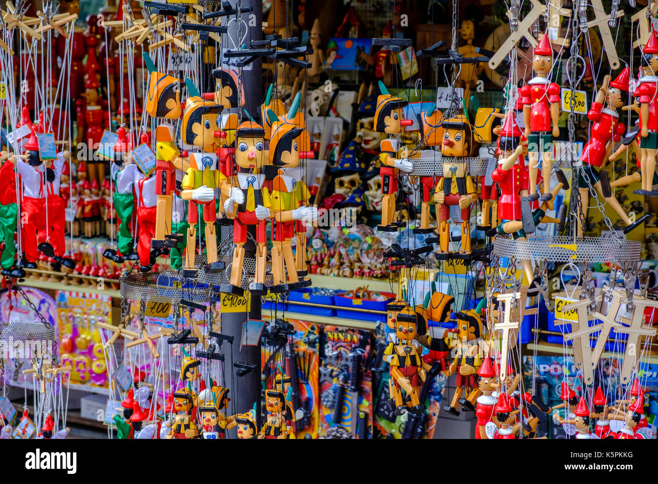 Small colorful woodcarved statues of Pinocchio are for sale as souvenirs Stock Photo