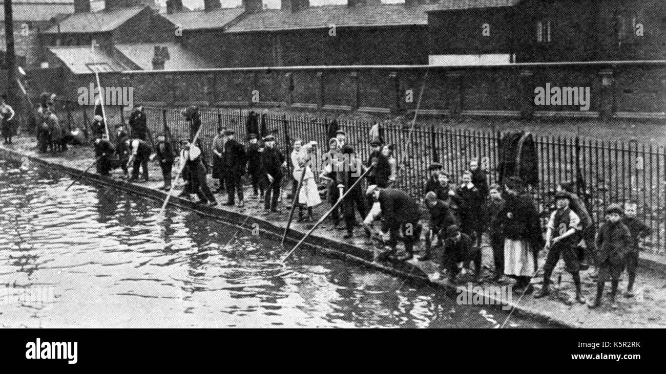 COAL FISHERS - A former scene in Manchester England  where poor families would gather coal dropped from barges into the canal Stock Photo