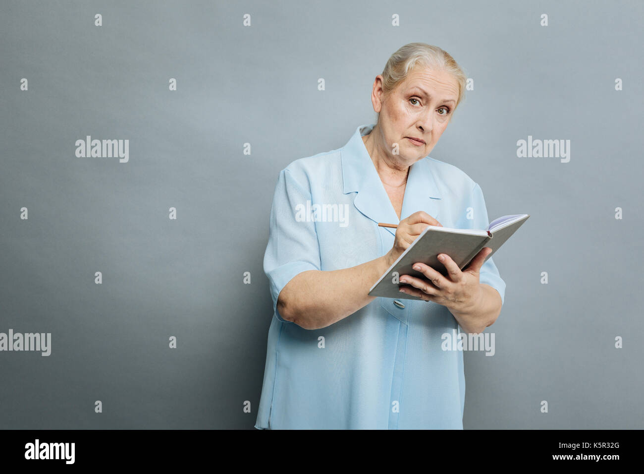 Attentive mature woman making notes Stock Photo