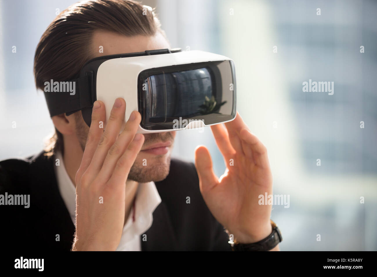 Businessman wearing vr glasses immersed in augmented reality. Stock Photo