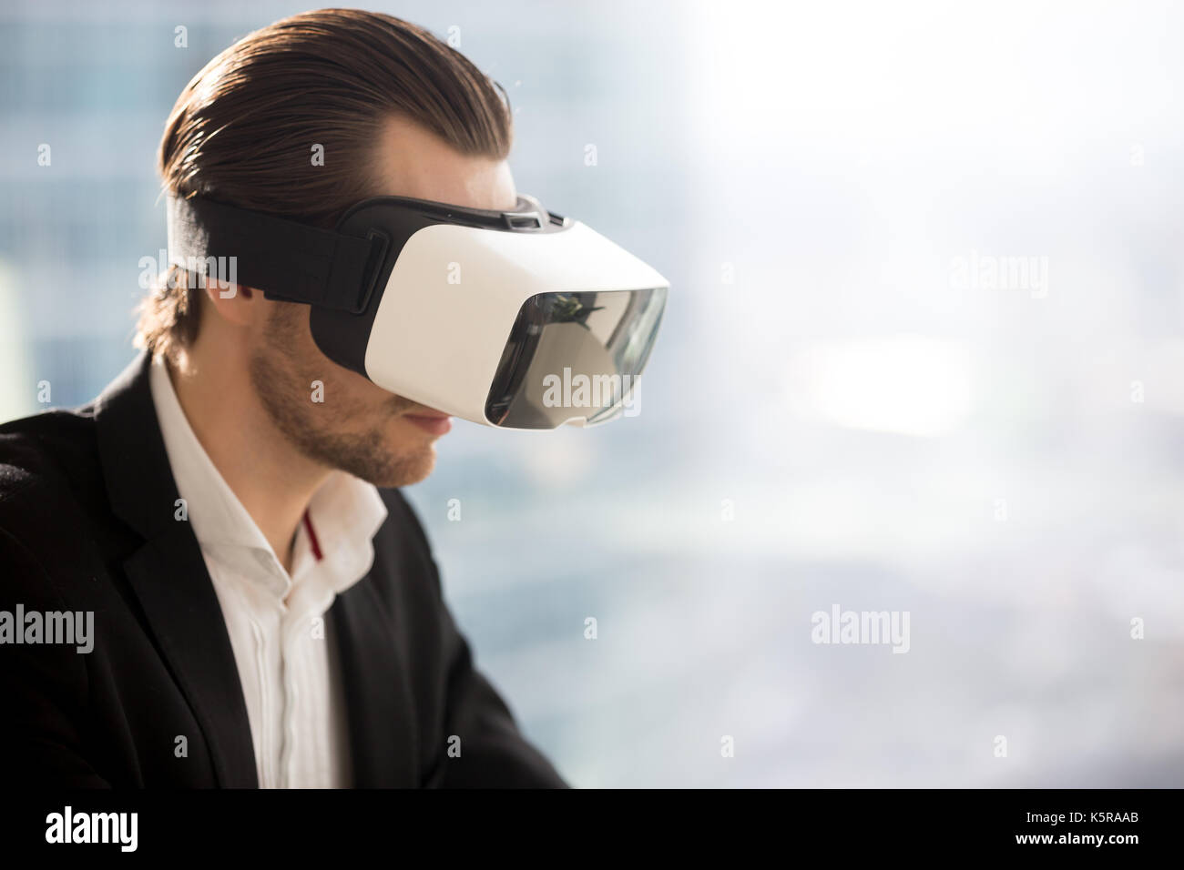 Young businessman wearing futuristic virtual reality glasses. Stock Photo