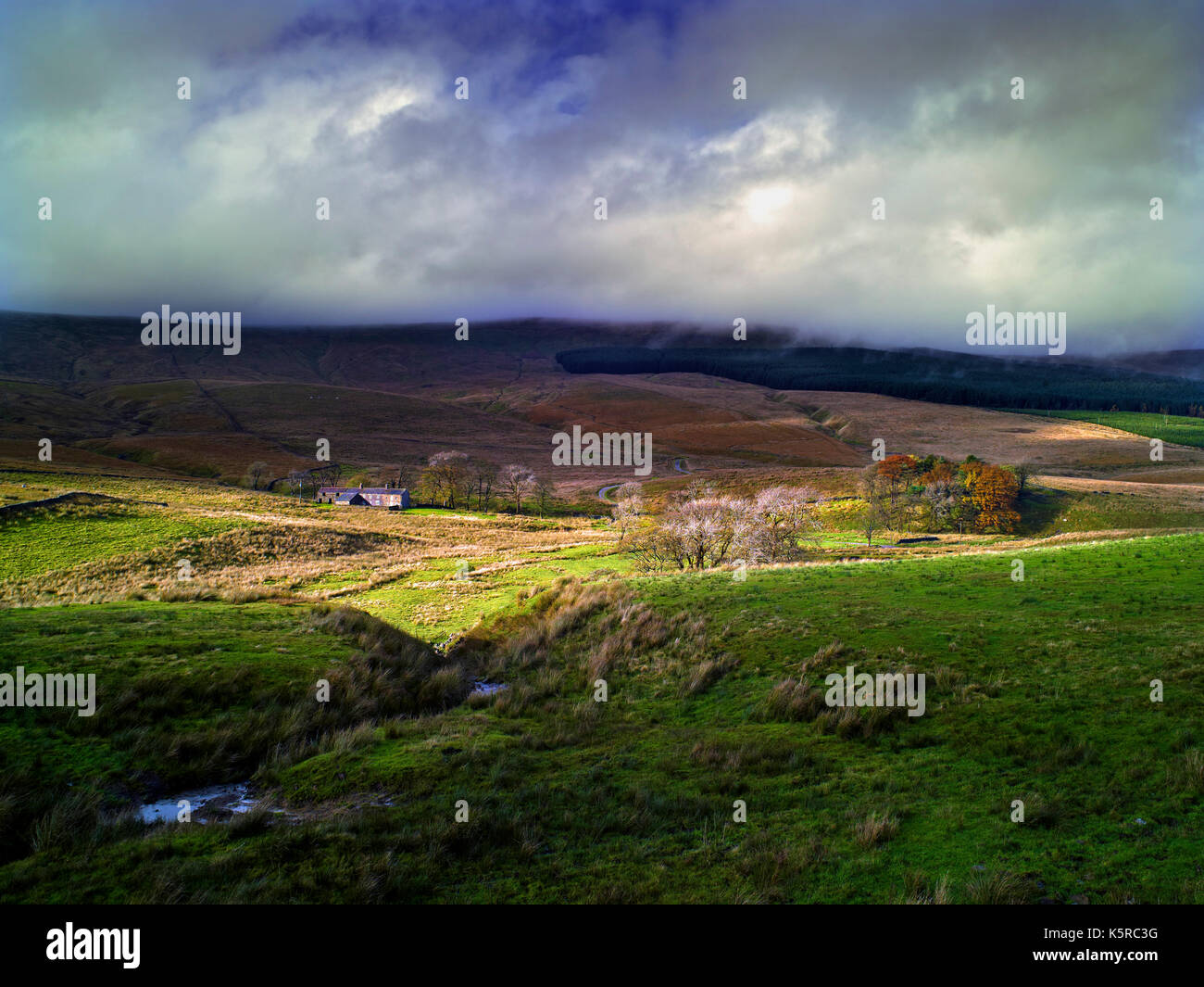 A view of Widdale in Wensleydale, North Yorkshire, as a beam of sunlight breaks through a stormy sky Stock Photo
