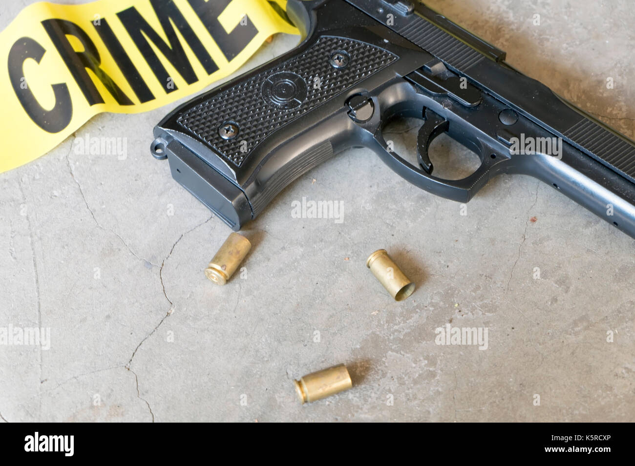 Crime scene concept with gun, crime scene tape and bullet casings Stock Photo