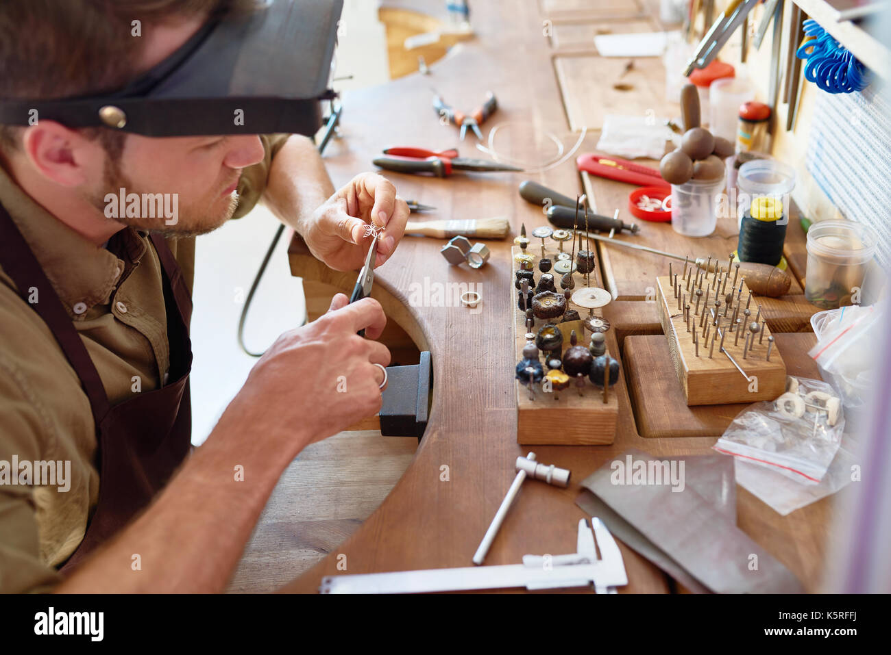 Portrait of jeweler making ring in forming and polishing it