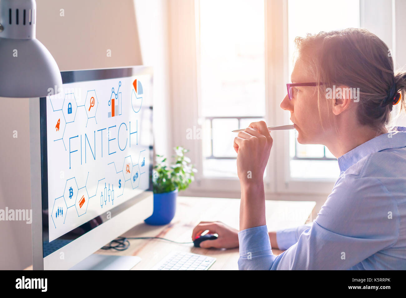 Fintech concept on computer screen with modern interface and innovative charts, female business person at office Stock Photo