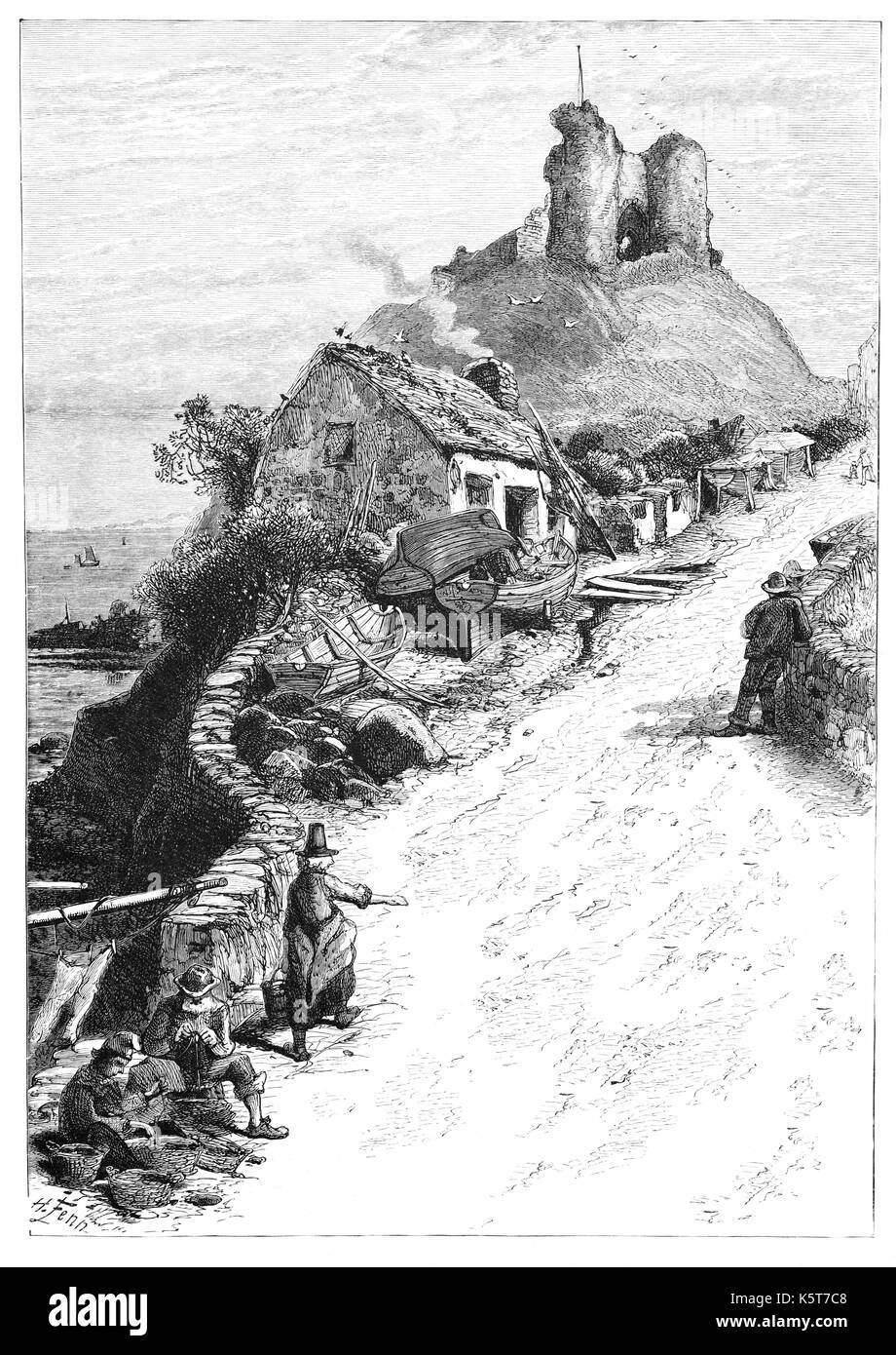 1870: A humble traditional thatched cottage, and locals, below Criccieth Castle situated on the headland overlooking Tremadog Bay. It was built by Llywelyn the Great of the kingdom of Gwynedd but it was heavily modified following its capture by English forces of Edward I in the late 13th century between  Criccieth, Gwynedd, North Wales. Stock Photo